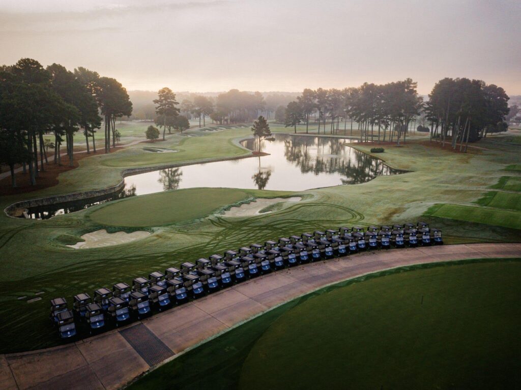 Golf carts lined up on a course, ready for a charity golf tournament.