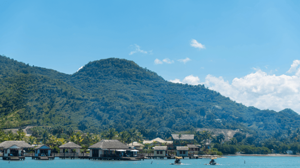 Waterfront bungalows beneath lush tropical hills