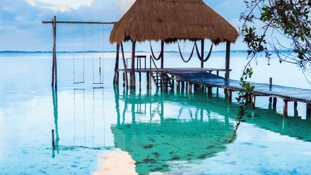 Thatched pier with hammocks above turquoise water