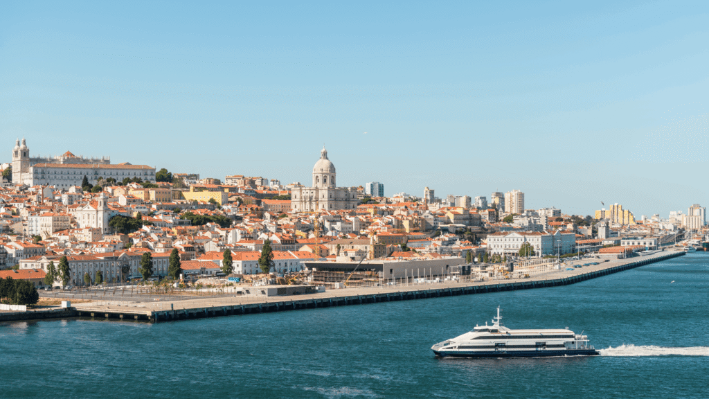 A peaceful waterside scene featuring Lisbon’s urban architecture across the water.